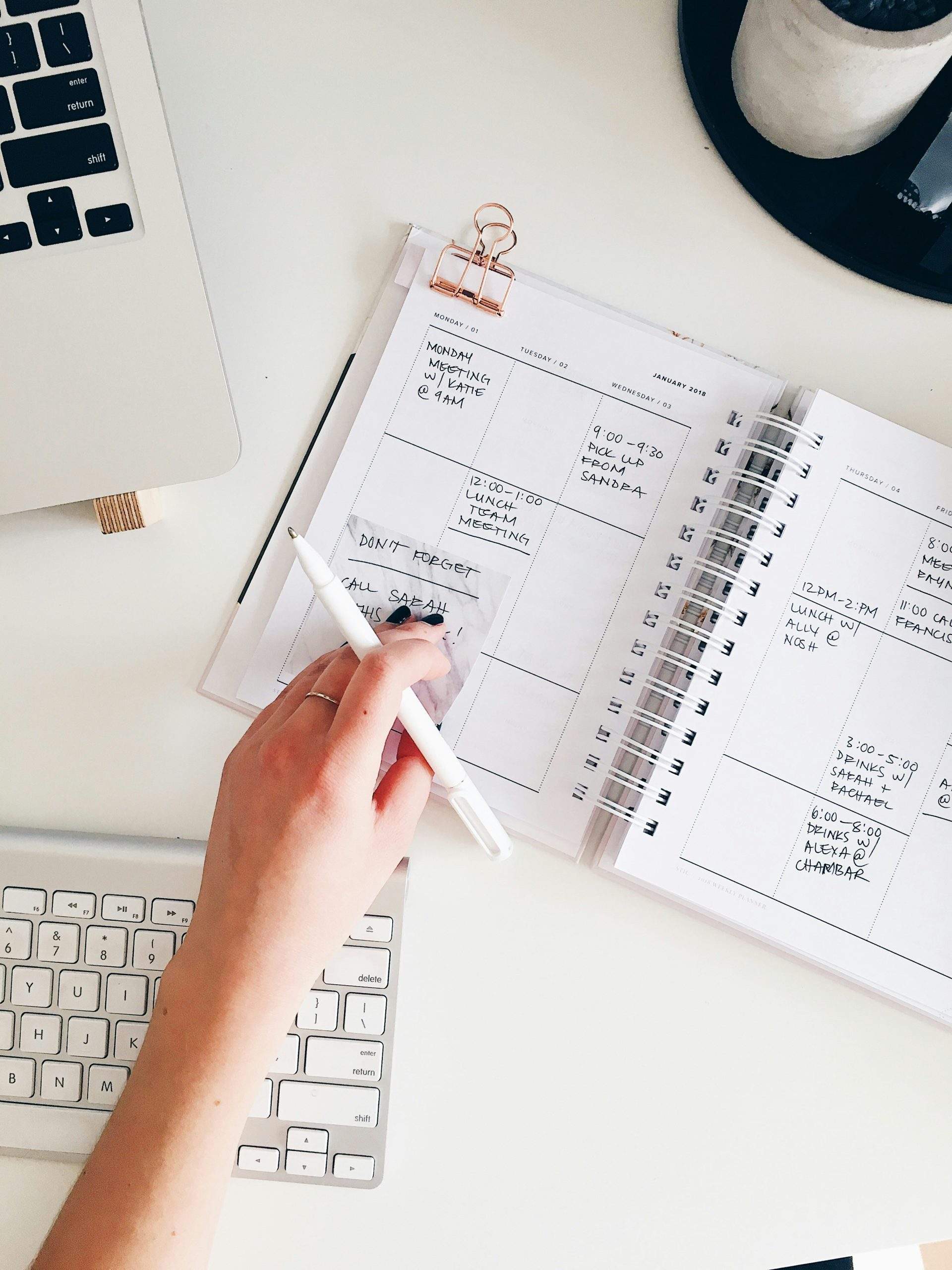 person holding notepad and pen flat lay photographyc